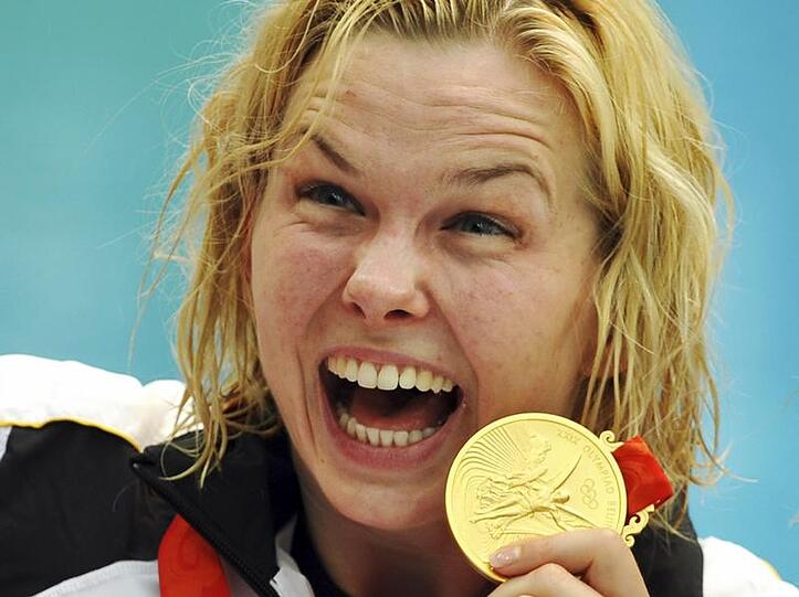 Britta Steffen zeigt voller Freude ihre Goldemedaille.