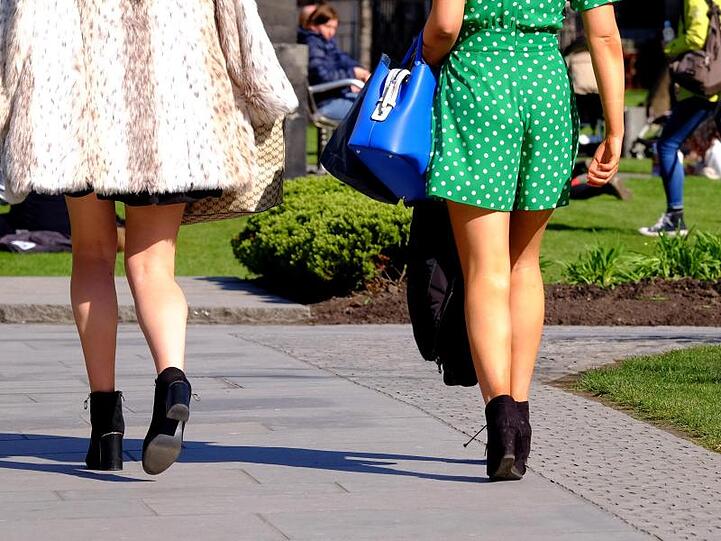 Zwei Frauen in kurzen Röcken gehen auf einem Weg. Foto: Jane Barlow/PA Wire/Archivbild
