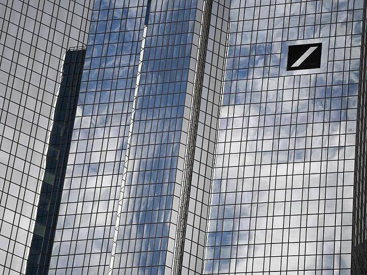 Wolken spiegeln sich in der Fassade der Zentrale der Deutschen Bank im Frankfurter Bankenviertel.