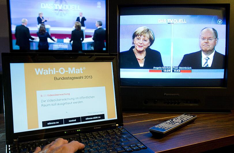 Bundeskanzlerin Angela Merkel (CDU) und der SPD-Spitzenkandidat Peer Steinbrück sind auf TV-Bildschirmen in Osnabrück (Niedersachsen) zu sehen. Im Vordergrund wurde der Wahl-O-Mat auf einem Notebook aufgerufen.