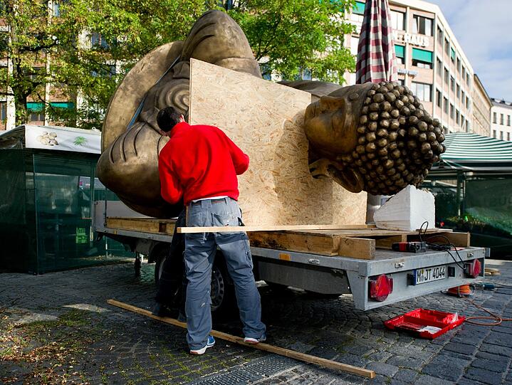 Ende einer Kunstaktion: Der liegende Buddha vom Viktualienmarkt wird abgebaut und auf einem Tieflader festgezurrt.