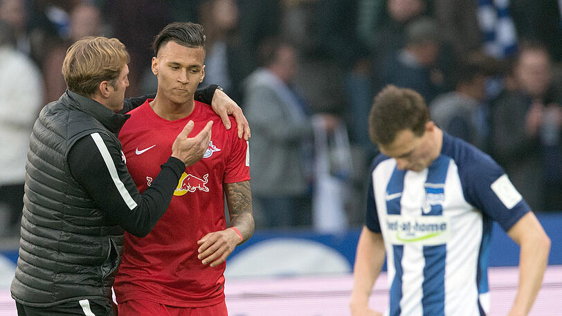 Leipzigs Trainer Ralf Hasenhüttl (l) freut sich nach Spielende mit Davie Selke über den Sieg, rechts steht Herthas Vladimir Darida mit gesenktem Kopf.