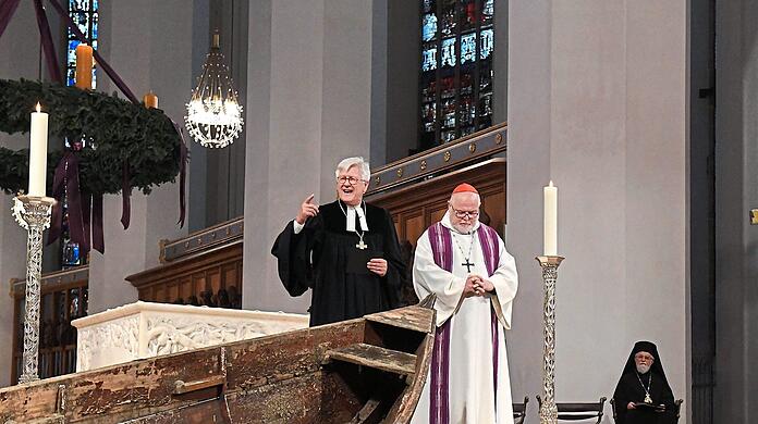 Heinrich Bedford-Strohm (li.) und Kardinal Marx beim ökumenischen Gottesdienst zum Gedenken an die Toten im Mittelmeer vor einem Jahr im Münchner Dom. Foto: Felix Hörhager/dpa