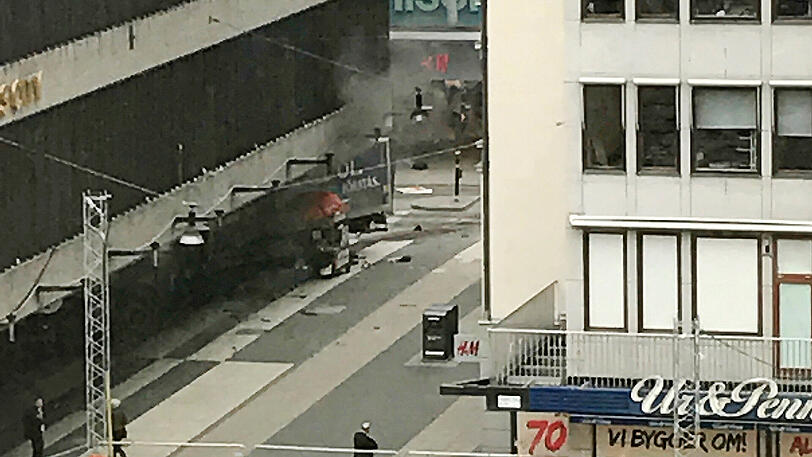 Ein LKW (Bildmitte) steht im Eingangsbereich eines Kaufhauses in Stockholm. Auf einer zentralen Einkaufsstraße in Stockholm war ein Lastwagen nach Medienberichten zunächst in eine Menschenmenge und dann in ein Kaufhaus gerast. Die Polizei spricht von Terrorverdacht.
