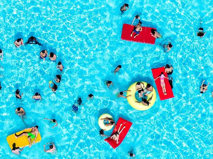 Badegäste planschen bei sommerlichen Temperaturen im Freibad Ricklinger Bad in Hannover.