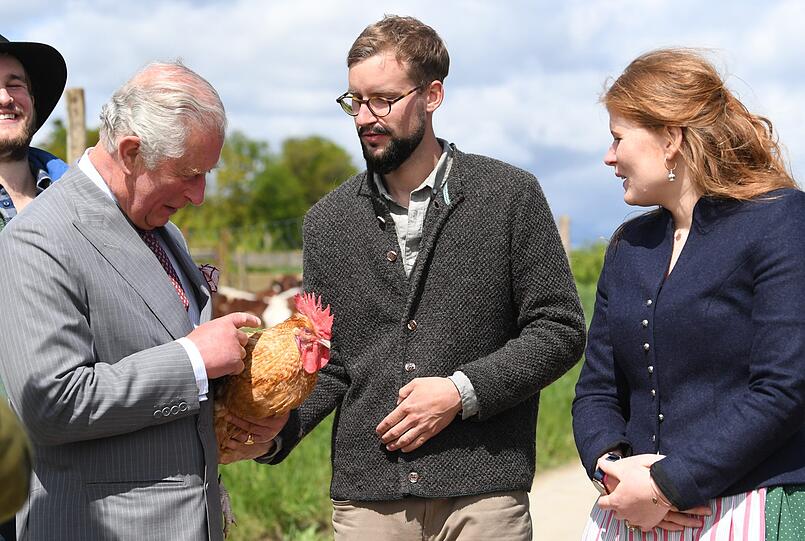 Charles streichelt ein Huhn.