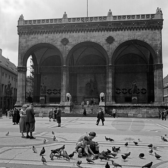 Taubenfüttern neben Nazipropaganda: An der Feldherrnhalle muss jeder Passant die sogenannten "Blutzeugen" mit dem Hitlergruß ehren.