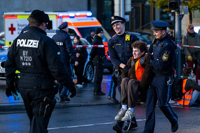 Polizisten tragen einen Klima-Aktivisten der Umweltschutzbewegung "Letzte Generation" weg, der zuvor auf der Prinzregentenstraße saß und den Verkehr blockiert hatte.