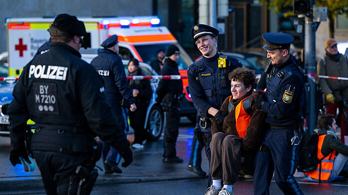 Polizisten tragen einen Klima-Aktivisten der Umweltschutzbewegung "Letzte Generation" weg, der zuvor auf der Prinzregentenstraße saß und den Verkehr blockiert hatte.