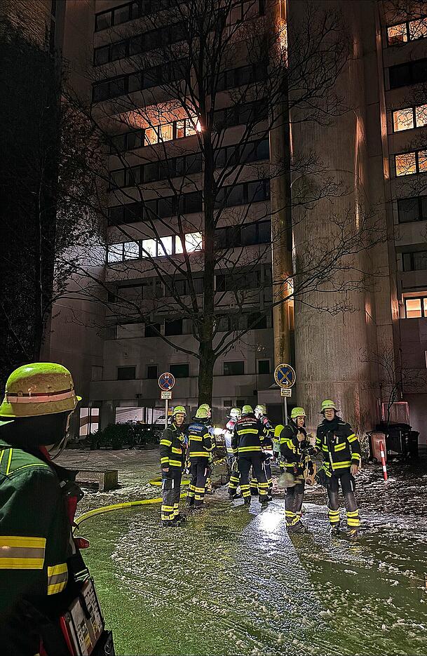 Das Hochhaus im Olympiadorf ist durch die Flammen hell erleuchtet.