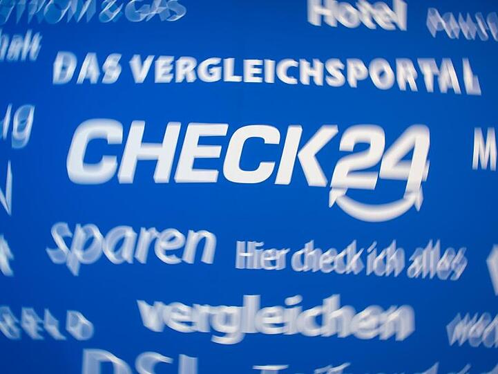 Das Logo von Check24 sowie zahlreiche Slogans auf einem Banner. Foto: picture alliance / Matthias Balk/dpa/archivbild