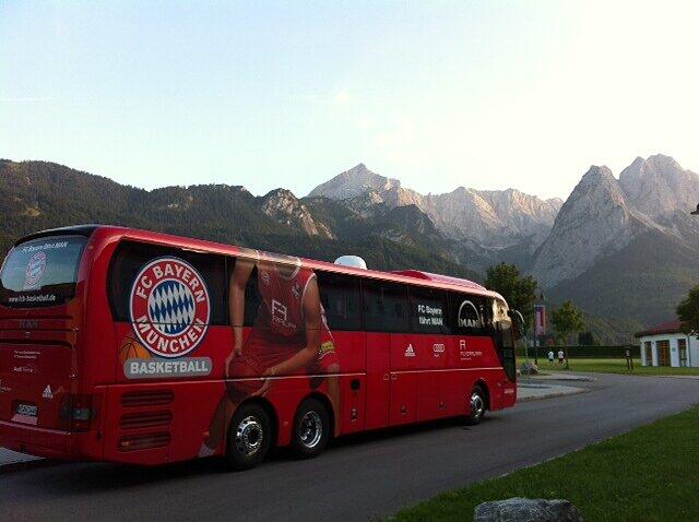 Der Bus der Basketballer vor dem beeindruckenden Bergpanorama.