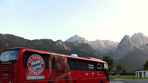 Der Bus der Basketballer vor dem beeindruckenden Bergpanorama.
