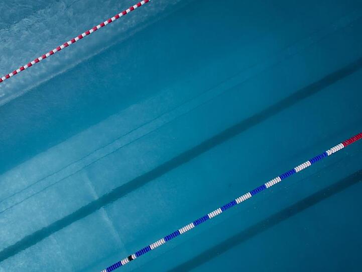 Das Luftbild einer Drohne zeigt ein menschenleeres Schwimmbecken. Foto: Friso Gentsch/dpa/Archiv
