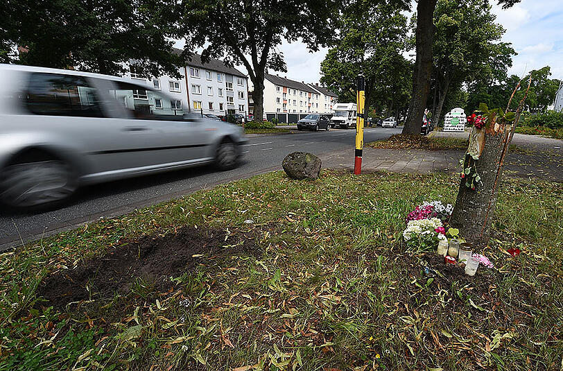 Blumen und Kerzen liegen im nördlichen Ortsteil Lüssum von Bremen nach einem tödlichen Verkehrsunfall an der Unfallstelle.