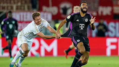 Münchens Eric Maxim Choupo-Moting (r) und Saarbrückens Manuel Zeitz kämpfen um den Ball.