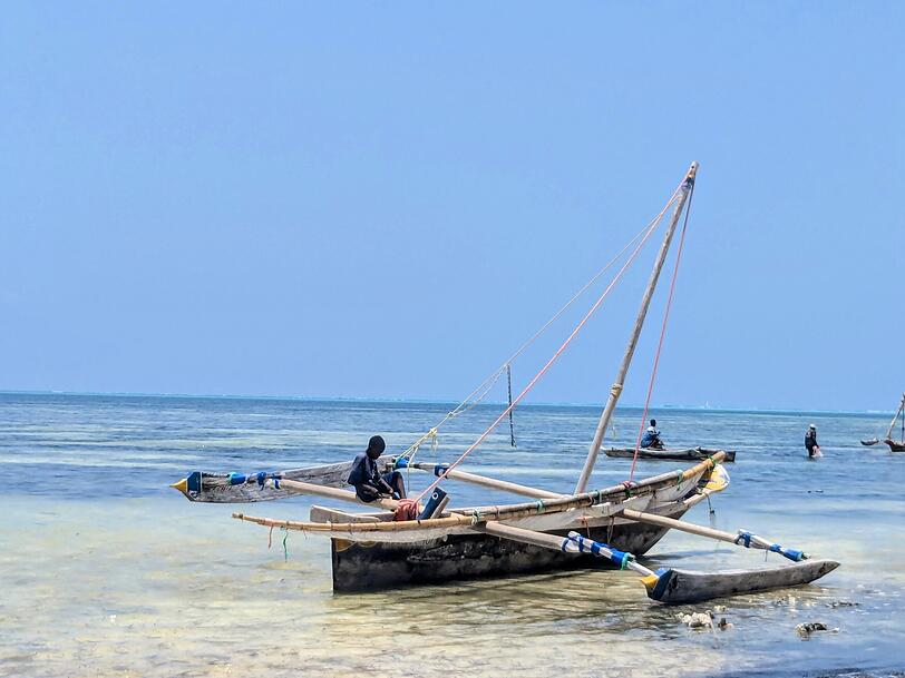 Ein traditionelles Holzboot am Strand von Sansibar. Viele Menschen auf der Insel leben von der Fischerei. Ein traditionelles Holzboot am Strand von Sansibar. Viele Menschen auf der Insel leben von der Fischerei.
