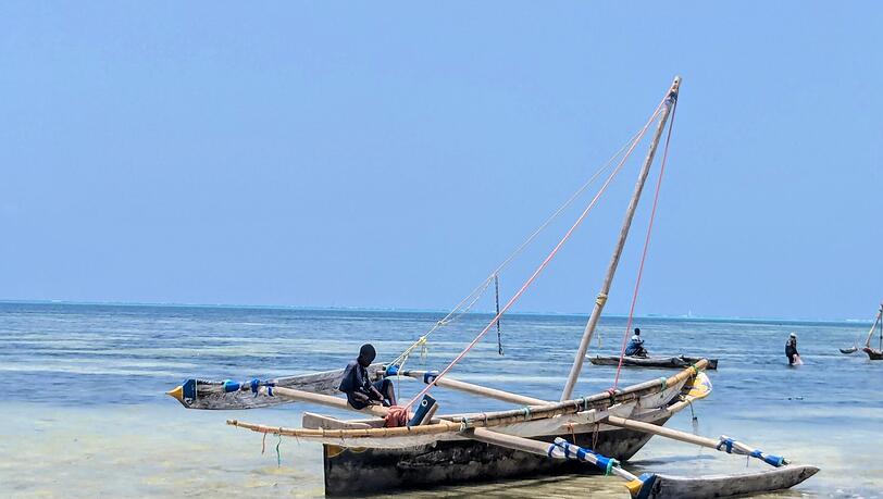 Ein traditionelles Holzboot am Strand von Sansibar. Viele Menschen auf der Insel leben von der Fischerei. Ein traditionelles Holzboot am Strand von Sansibar. Viele Menschen auf der Insel leben von der Fischerei.