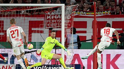 Leipzigs Christopher Nkunku (r) erzielt gegen Freiburgs Torwart Mark Flekken das Tor zum 4:0.