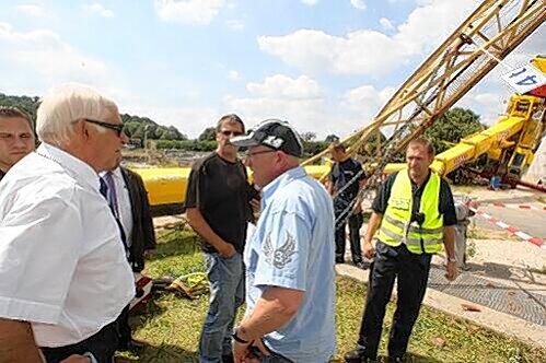 Bürgermeister Gerd Lohwasser (li.) machte sich selbst ein Bild von der Zerstörung und sprach mit dem Kranführer (schwarze Kappe).