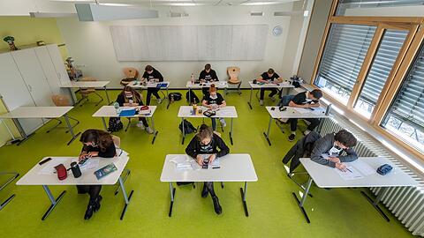 Abiturienten sitzen in einem Klassenzimmer.