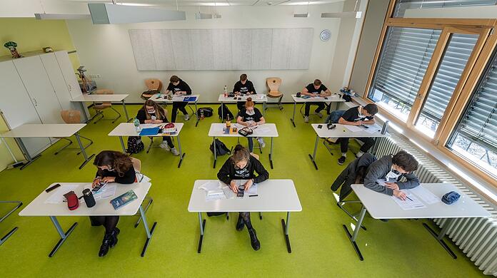Abiturienten sitzen in einem Klassenzimmer.