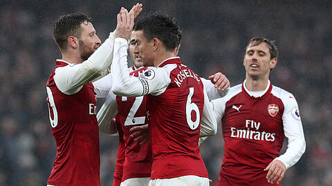 Arsenals Shkodran Mustafi (l) und Laurent Koscielny (2.v.r) jubeln mit ihren Teamkollegen über den Sieg.