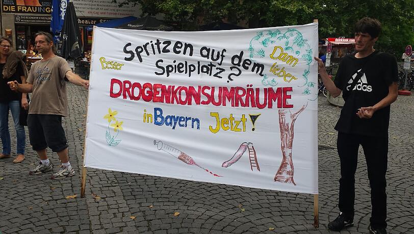 Zwei Demonstranten mit ihrem Banner bei der Mahnwache am Sendlinger Tor. Foto: Linda Jessen Zwei Demonstranten mit ihrem Banner bei der Mahnwache am Sendlinger Tor. Foto: Linda Jessen