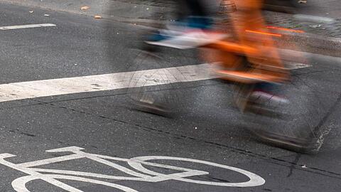 Ein Fahrradfahrer fährt in der Innenstadt über einen Radweg.