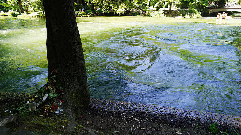 Blumen am Baum zeigen die Stelle, an der vor rund zwei Wochen ein 15-jähriges Mädchen im Eisbach ertrunken ist.