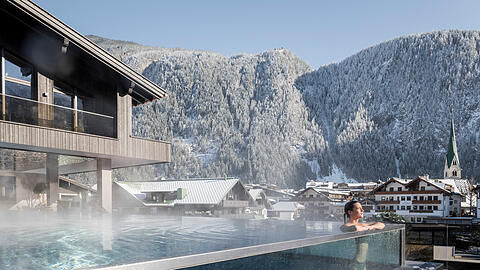 Das Neuhaus Zillertal Resort in Mayrhofen: Im warmen Infinitypool entspannen, mit Blick auf verschneite Berge. Herrlich, oder?