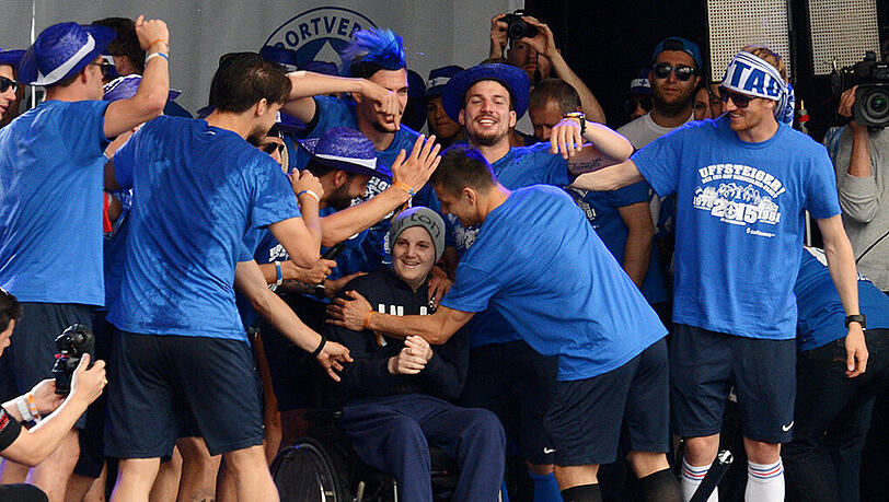 Die Fußballer des SV Darmstadt 98 feiern am 25. Mai 2015 in der Innenstadt von Darmstadt zusammen mit dem krebskranken ehemaligen Tennisspieler Jonathan "Johnny" Heimes (Mitte) den Bundesliga-Aufstieg. Die Fußballer des SV Darmstadt 98 feiern am 25. Mai 2015 in der Innenstadt von Darmstadt zusammen mit dem krebskranken ehemaligen Tennisspieler Jonathan "Johnny" Heimes (Mitte) den Bundesliga-Aufstieg.
