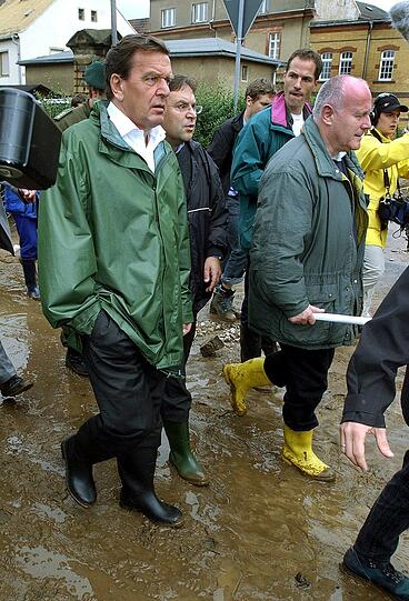 Der Kanzler in Gummistiefeln: Bundeskanzler Gerhard Schröder und der ehemalige sächsische Ministerpräsident Georg Milbradt (CDU) gehen durch die vom Hochwasser verwüstete sächsische Kreisstadt Grimma im August 2002.