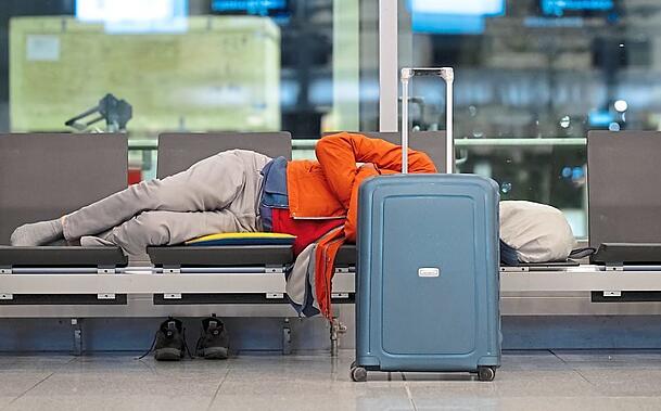 Ein Passagier schläft am Flughafen München auf einer Bank. Die Gewerkschaft Verdi will mit einem zweitägigen Warnstreik am Münchner Flughafen den Druck in den Tarifverhandlungen im öffentlichen Dienst machen. +++ dpa-Bildfunk +++ Ein Passagier schläft am Flughafen München auf einer Bank. Die Gewerkschaft Verdi will mit einem zweitägigen Warnstreik am Münchner Flughafen den Druck in den Tarifverhandlungen im öffentlichen Dienst machen. +++ dpa-Bildfunk +++