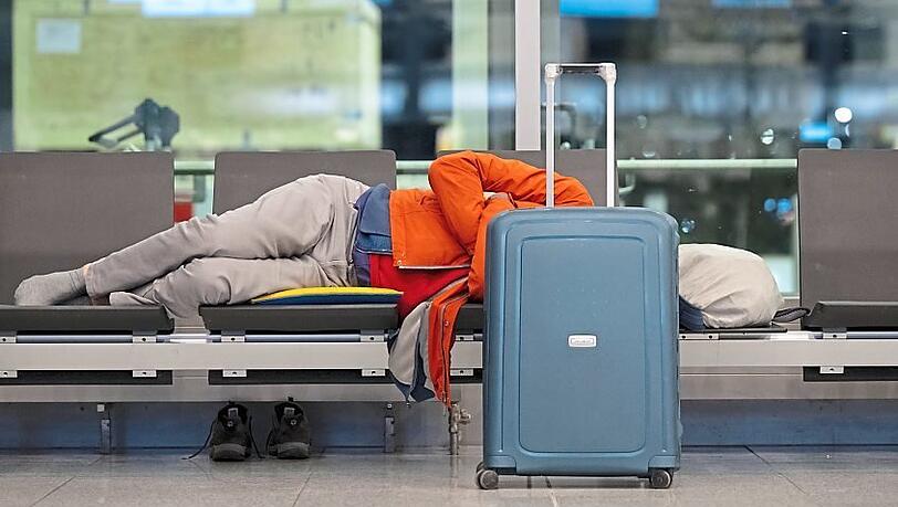 Ein Passagier schläft am Flughafen München auf einer Bank. Die Gewerkschaft Verdi will mit einem zweitägigen Warnstreik am Münchner Flughafen den Druck in den Tarifverhandlungen im öffentlichen Dienst machen. +++ dpa-Bildfunk +++ Ein Passagier schläft am Flughafen München auf einer Bank. Die Gewerkschaft Verdi will mit einem zweitägigen Warnstreik am Münchner Flughafen den Druck in den Tarifverhandlungen im öffentlichen Dienst machen. +++ dpa-Bildfunk +++