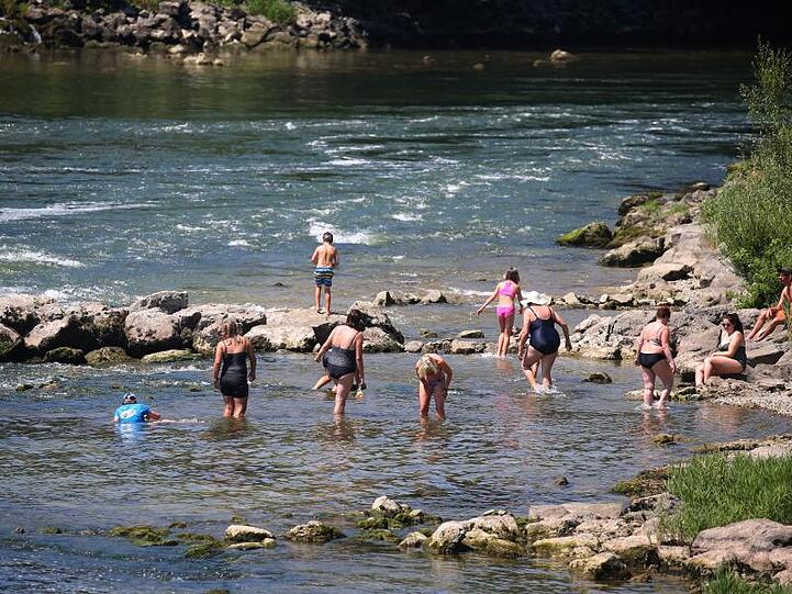 Ausflügler suchen Abkühlung im seichten Wasser des Lechs. Foto: Karl-Josef Hildenbrand/dpa/Archivbild