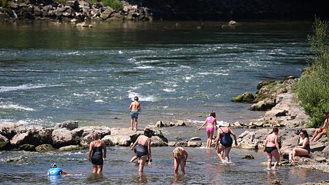 Ausflügler suchen Abkühlung im seichten Wasser des Lechs. Foto: Karl-Josef Hildenbrand/dpa/Archivbild