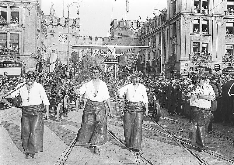 Halb München ist auf den Beinen beim Museums-Festumzug am 5. Mai 1925. Sogar ein Flugzeug wird durch die Stadt (hier am Karlstor) gezogen.