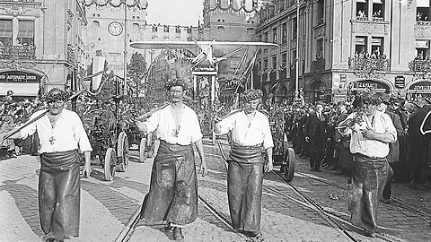 Halb München ist auf den Beinen beim Museums-Festumzug am 5. Mai 1925. Sogar ein Flugzeug wird durch die Stadt (hier am Karlstor) gezogen.