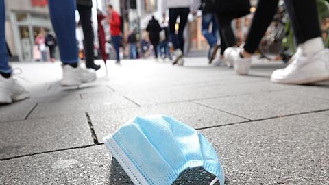 Ein auf dem Boden liegender Mund-Nasen-Schutz in der Kölner Innenstadt. Der Bund will eine ergänzende Maskenpflicht einführen.
