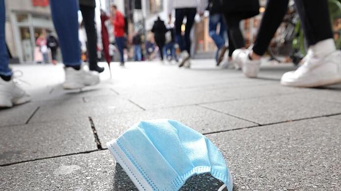 Ein auf dem Boden liegender Mund-Nasen-Schutz in der Kölner Innenstadt. Der Bund will eine ergänzende Maskenpflicht einführen.