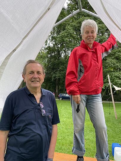 Alfred Eibl (l.) von Attac baut ein Zelt auf.