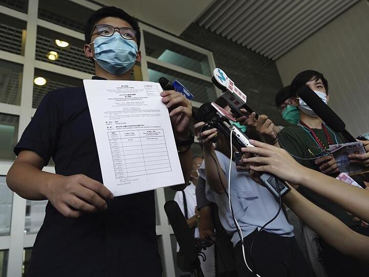 Aktivist Joshua Wong zeigt Journalisten die Nominierungsunterlagen für die Parlamentswahl im September.