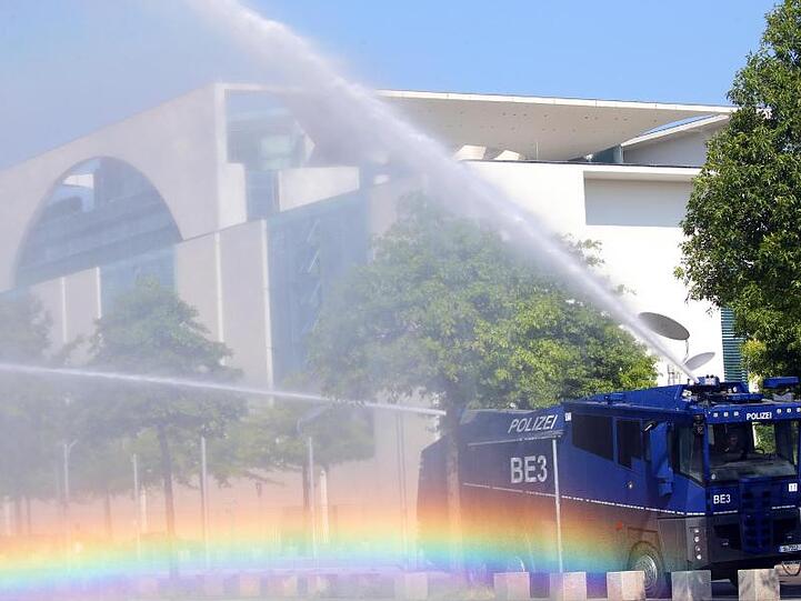 Bei Temperaturen um 30 Grad und extremer Trockenheit bewässert ein Wasserwerfer der Polizei die Grünanlagen vor dem Bundeskanzleramt.