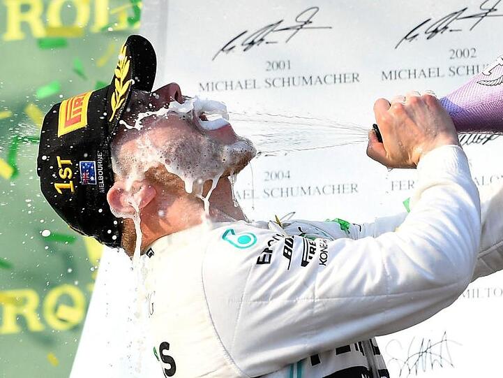 Mercedes-Pilot Valterri Bottas aus Finnland feiert seinen Sieg auf dem Podium mit Champagner.