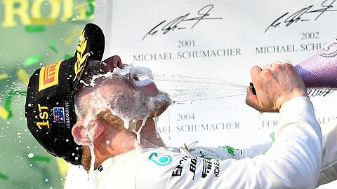 Mercedes-Pilot Valterri Bottas aus Finnland feiert seinen Sieg auf dem Podium mit Champagner.