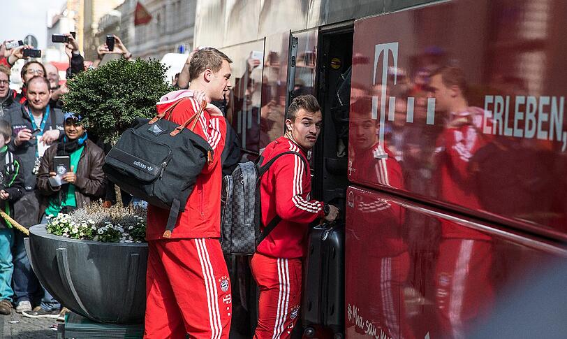 Müde Bayern-Spieler schleppen sich nach einer kurzen Nacht zum Mannschaftsbus.