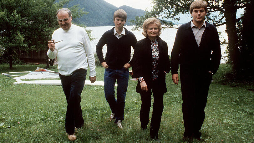 Familienidylle: Bundeskanzler Helmut Kohl (wie oft mit Pfeife), seine Gattin Hannelore und die beiden Söhne Walter und Peter (r.) laufen im Juni 1981 über eine grüne Wiese am Wolfgangsee im Salzburger Land.
