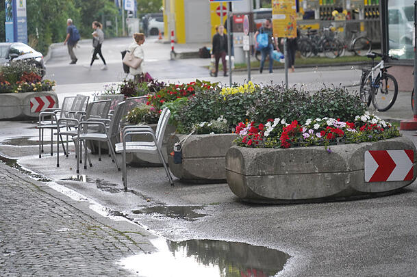 Die Stühle in der Schmied-Kochel-Straße bleiben nicht nur bei Regenwetter leer. Eine Anwohnerin erinnern die Pflanzentröge an Terrorabwehr.