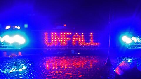 Während einer Unfallaufnahme spiegelt sich der Schriftzug "Unfall" auf dem Dach eines Polizeiwagens. (Symbolbild)